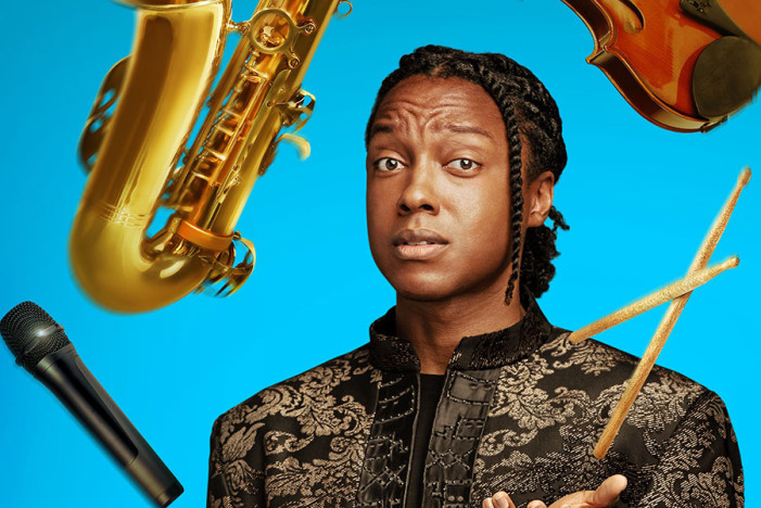 Josh Johnson stands before a blue background, juggling drum sticks, a black microphone, a saxaphone and a violin