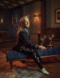 Alan Cumming posing with two Emmy Awards