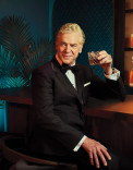 Christopher McDonald poses in a tuxedo and cocktail in the Emmy Photo Studio