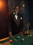 Ernest Harden Jr. in a tuxedo posing with his Emmy Award