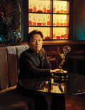 Hiro Murai in a tuxedo posing with his Emmy Award
