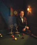 Matthew Rhys posing with his two Emmy Awards at a pool table