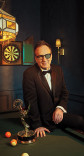 Saul Metzstein in a tuxedo poses with his Emmy Award