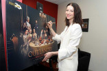 Actor Catriona Balfe signs a poster at the Outlander: From Scotland to Paris event, April 5, 2016, at the NYU Skirball Center for the Performing Arts in New York City. 