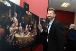 Production designer Jon Gary Steele signs a poster at the Outlander: From Scotland to Paris event, April 5, 2016, at the NYU Skirball Center for the Performing Arts in New York City. 