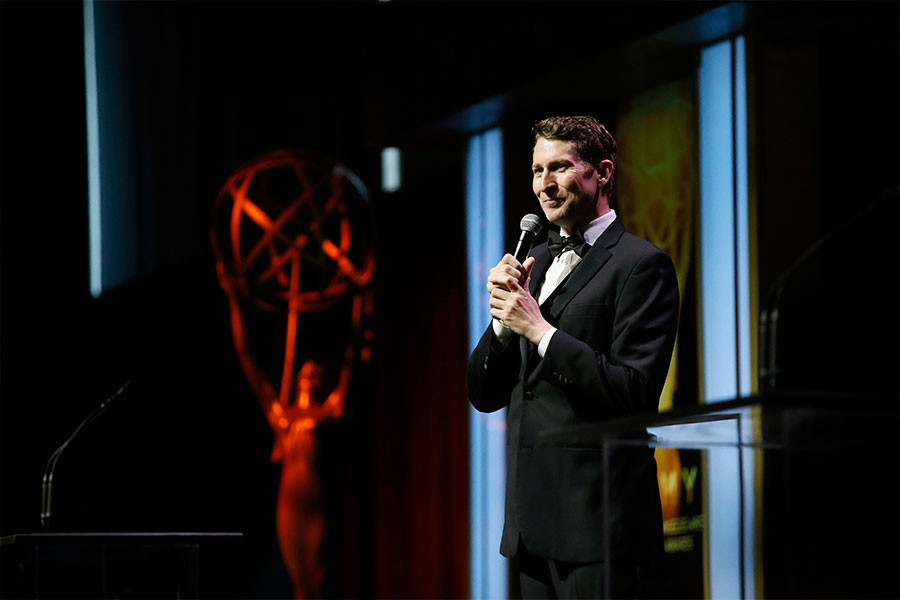 Host Scott Aukerman entertains the audience at the 67th Los Angeles Area Emmy Awards July 25, 2015, at the Skirball Cultural Center in Los Angeles, California.