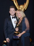 Downton Abbey hairstylists Adam James Phillips (l) and Magi Vaughan (r) celebrate their win at the 2014 Primetime Creative Arts Emmys.