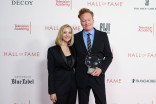 Lisa Kudrow standing to the left of Conan O'Brien