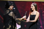 Loreena Arbus presents an award to Natalie Whalen at the 36th College Television Awards at the Skirball Cultural Center in Los Angeles, California, April 23, 2015.