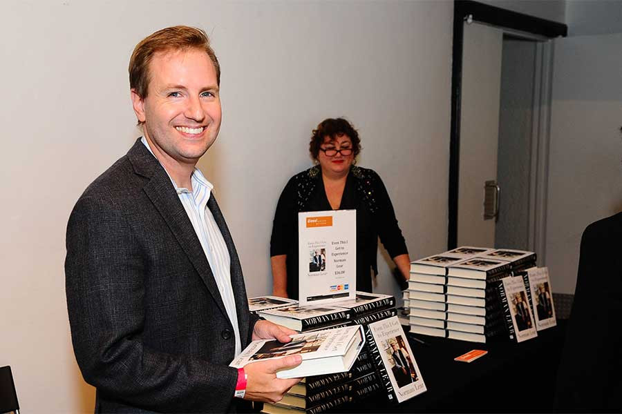 Television Academy president and COO Maury McIntyre looks over Norman Lear's new book at An Evening with Norman Lear at the Montalban Theater in Hollywood.