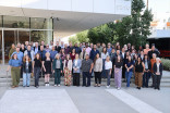 A group of people standing outsde of a modern building posing for a photo