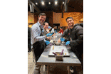 Two participants wearing blue gloves at a table prepping food