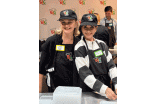 Two participants wearing "BIG" branded hats and aprons