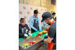 Three participants at the OBKLA event chopping vegetables