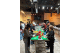 Volunteers wearing aprons prepping vegetables at a table